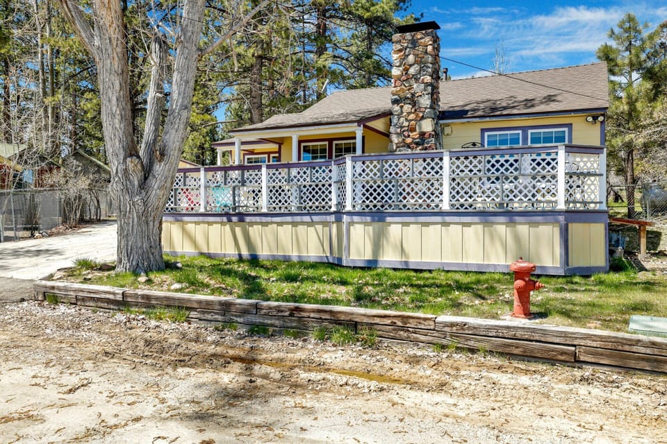 Welcoming cabin entry surrounded by towering pine trees, offering fresh mountain air and a peaceful forest setting—the perfect first impression for your Big Bear Lake getaway.