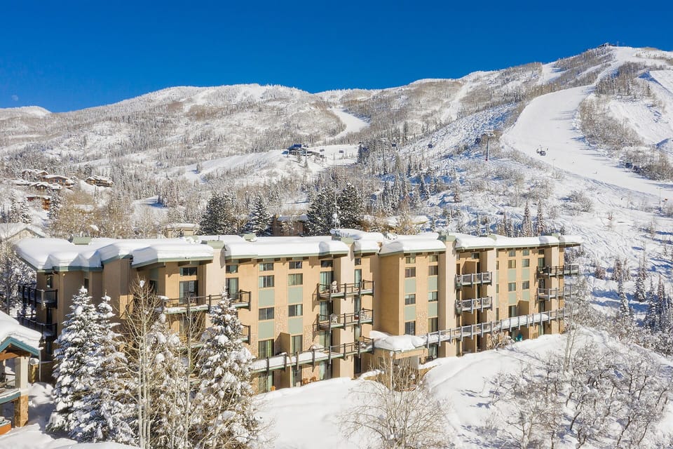 Mountain resort nestled in snow-covered slopes with ski lifts visible on the mountainside.