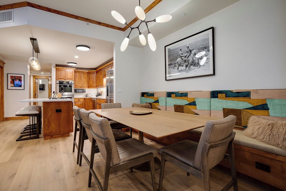 You'll love gathering around this stunning dining table, with warm wood tones and colorful art creating the perfect backdrop for memorable meals.