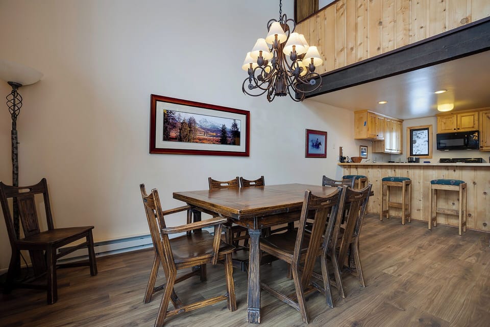 Gather around your rustic dining table where warm wood tones and mountain views create the perfect setting for memorable meals together.