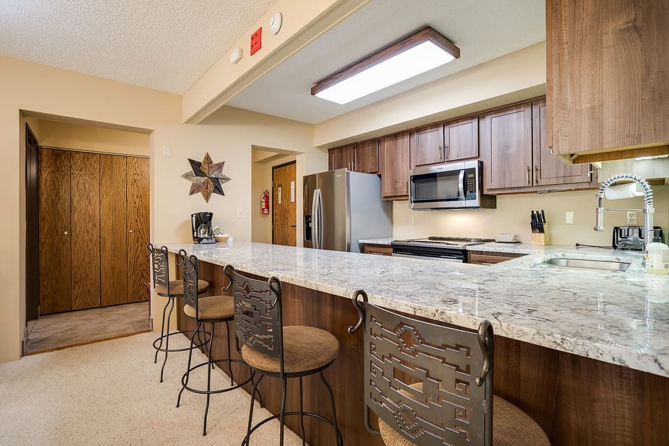Your spacious kitchen features granite countertops, modern appliances, and a breakfast bar where you can enjoy morning coffee.