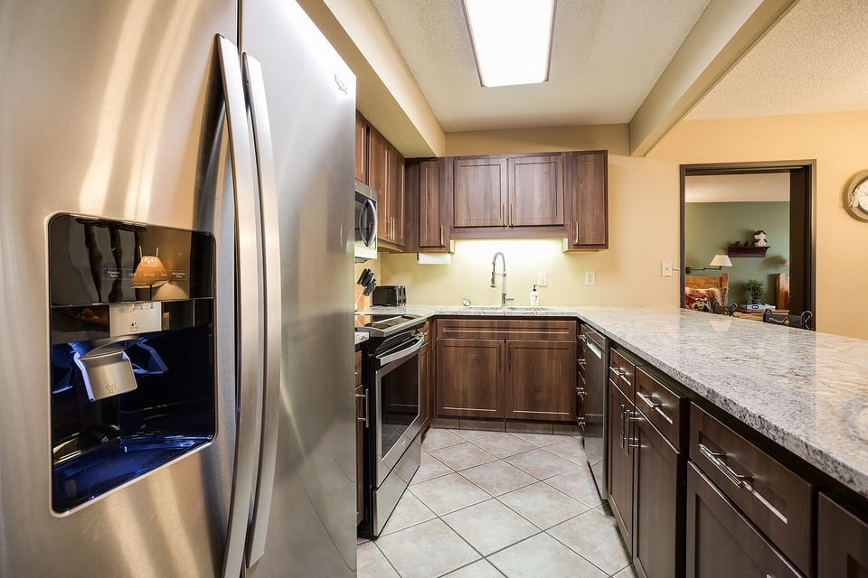 Your fully equipped kitchen features granite counters, stainless appliances, and rich wood cabinets—perfect for creating memorable meals together.
