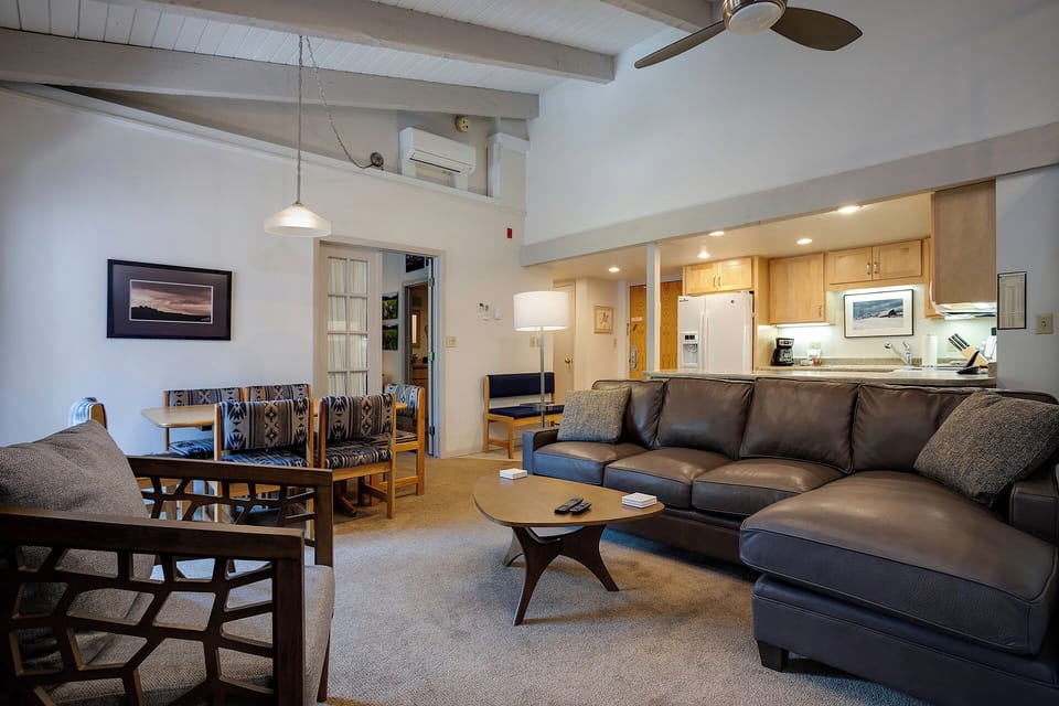 Relax in your spacious living area with exposed beams and modern comforts, perfect for unwinding after mountain adventures.