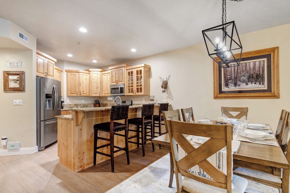 Gather around the inviting dining table or casual breakfast bar, where warm wood tones and thoughtful design create the perfect setting for your mountain meals and memorable conversations.