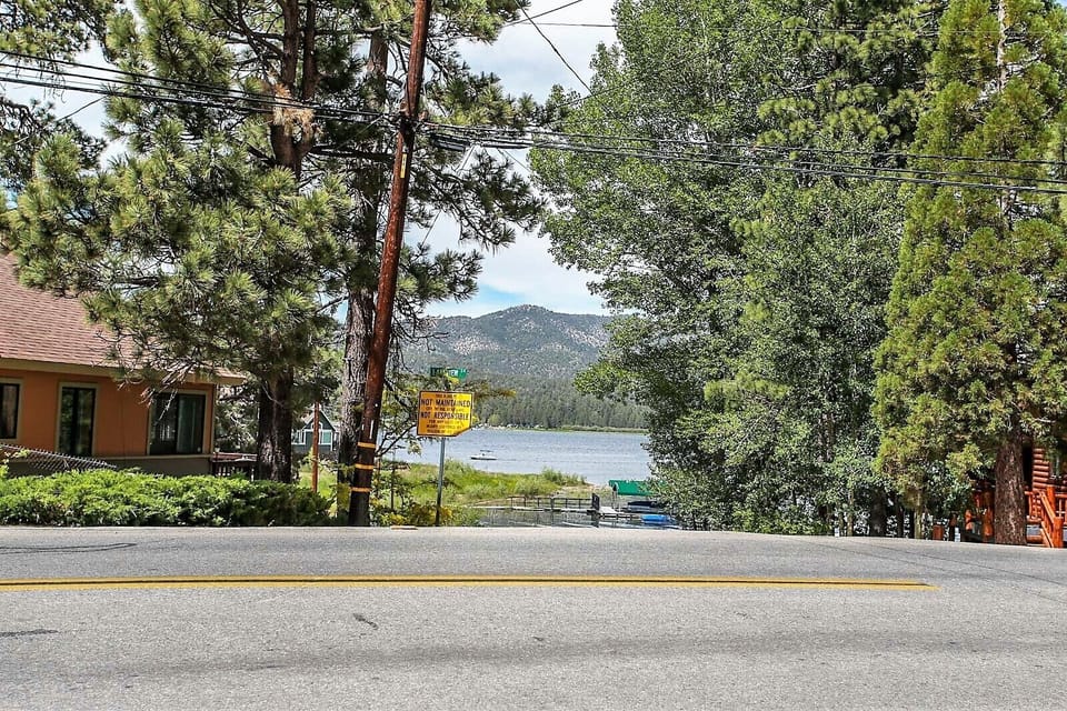 Welcoming cabin entry surrounded by towering pine trees, offering fresh mountain air and a peaceful forest setting—the perfect first impression for your Big Bear Lake getaway.