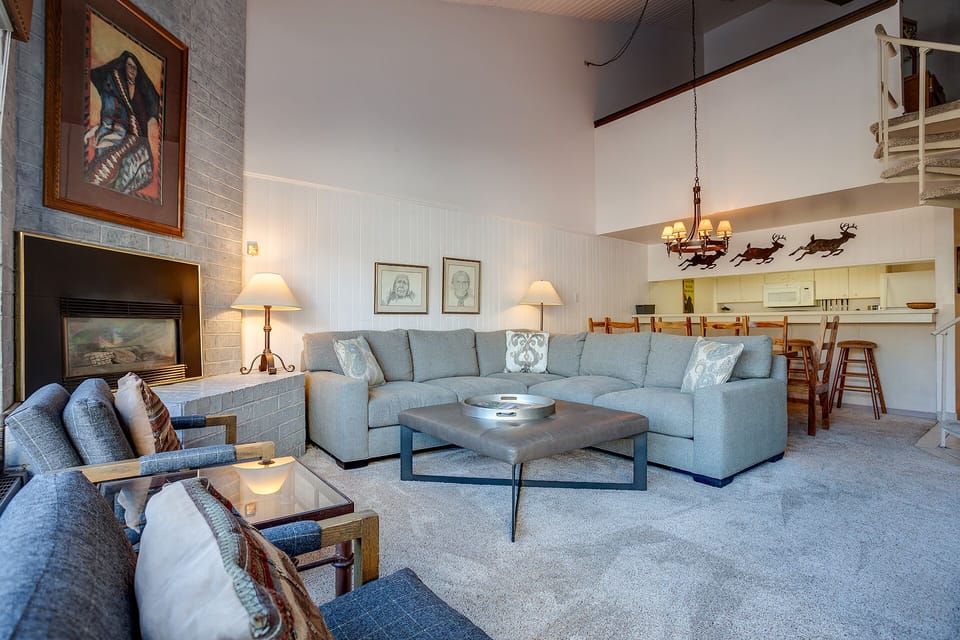Unwind in your spacious living area with a cozy sectional sofa and warm fireplace, perfect for relaxing after mountain adventures.