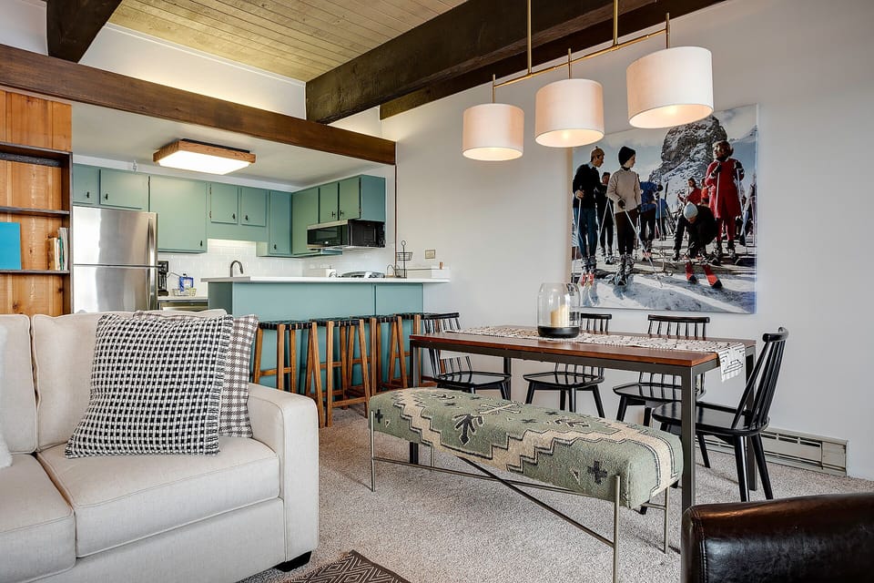 Gather around your sleek dining table while savoring mountain memories captured in stunning ski photography above.