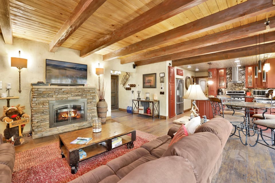 This sprawling living area flows effortlessly into the gourmet kitchen. With rustic beamed ceilings and high-end finishes, it's a perfect setup for entertaining.