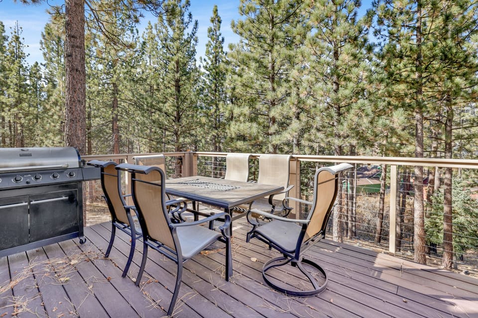 The spacious outdoor deck includes a full dining set and a gas BBQ grill, making it the perfect spot for family cookouts in the fresh mountain air.