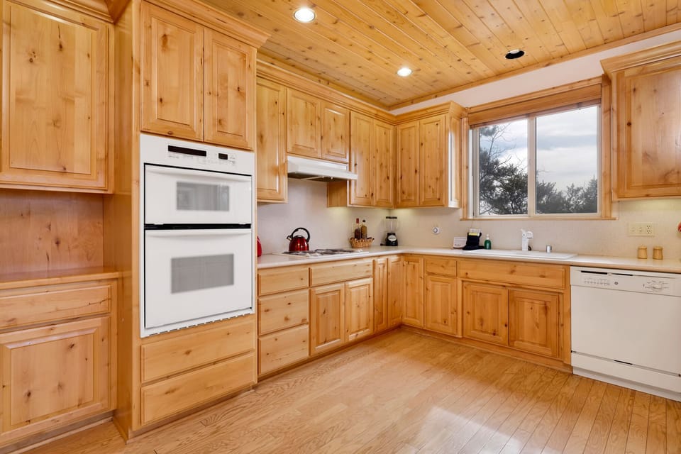 Fully equipped cabin kitchen with ample cabinetry, stove, fridge, microwave, and coffee maker—perfect for cooking meals, morning coffee, and feeling right at home on your stay.