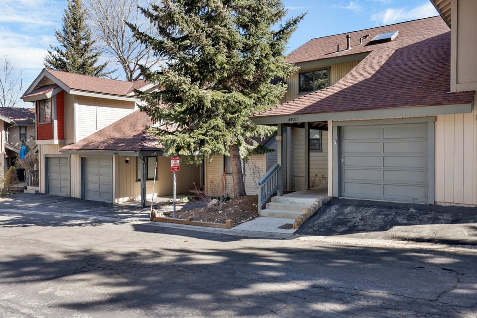Exterior view of the home showcasing its mountain-style architecture and convenient garage access within a peaceful residential community. Near Ski slopes walking distance so you dont have to pay for parking