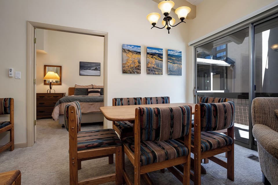 Gather around your private dining table with mountain views through floor-to-ceiling windows, while your cozy bedroom awaits just steps away.