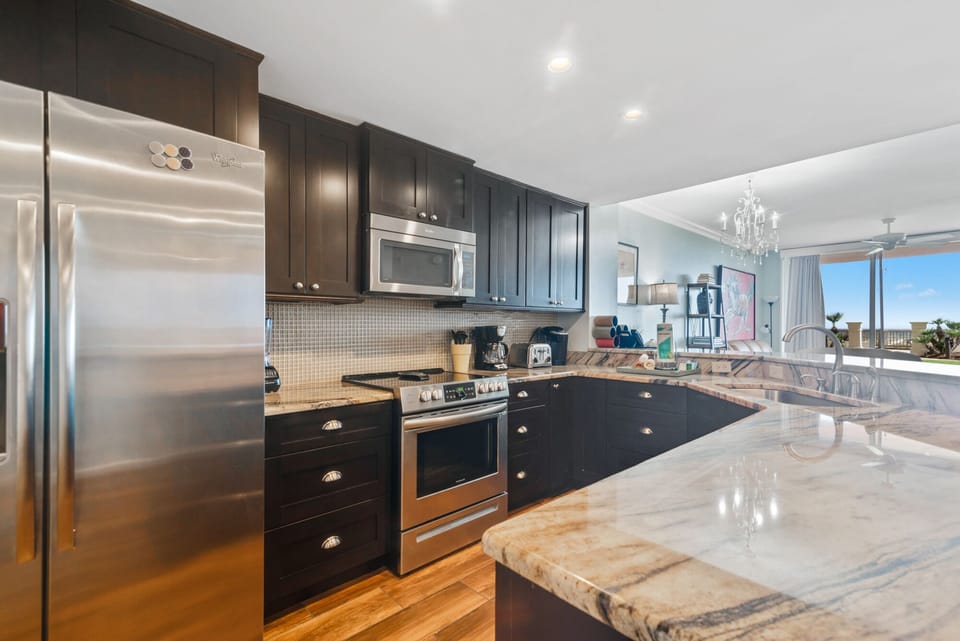 This fully functional kitchen boasts stainless steel appliances, sleek countertops, a decorative backsplash, and ample cabinet storage, ideal for everyday cooking and entertaining.