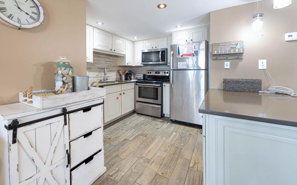 Kitchen featuring stainless appliances, coastal decor, breakfast bar, and a welcoming atmosphere for culinary adventures