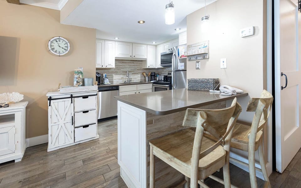 Elegant kitchen featuring modern stainless appliances, Keurig and coffee maker, and rustic wooden accents for a cozy feel