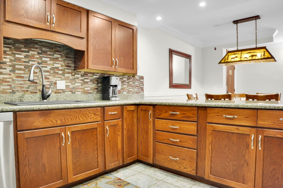 Park Station 113 has wood cabinets, tiled backsplash and recessed lighting.