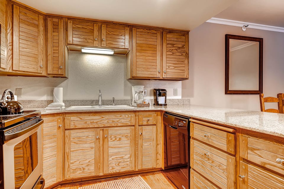 The well-equipped kitchen offers stainless steel appliances and wood cabinets.