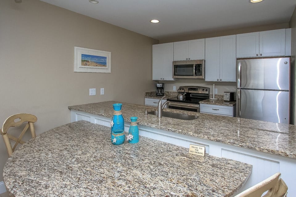 Ocean Dunes 316 - Kitchen with Granite Counter Tops and Stainles - The newly renovated Kitchen / Dining Area features all stainless appliances, granite counters and dining bar having seating for four, and tile flooring throughout.