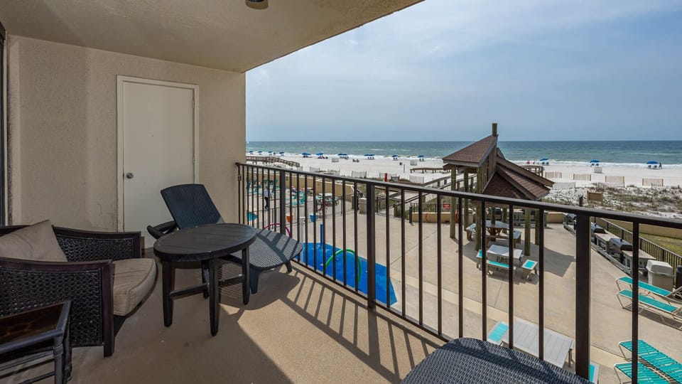 Relax on the balcony with comfortable seating and enjoy the beautiful beach view just steps away
