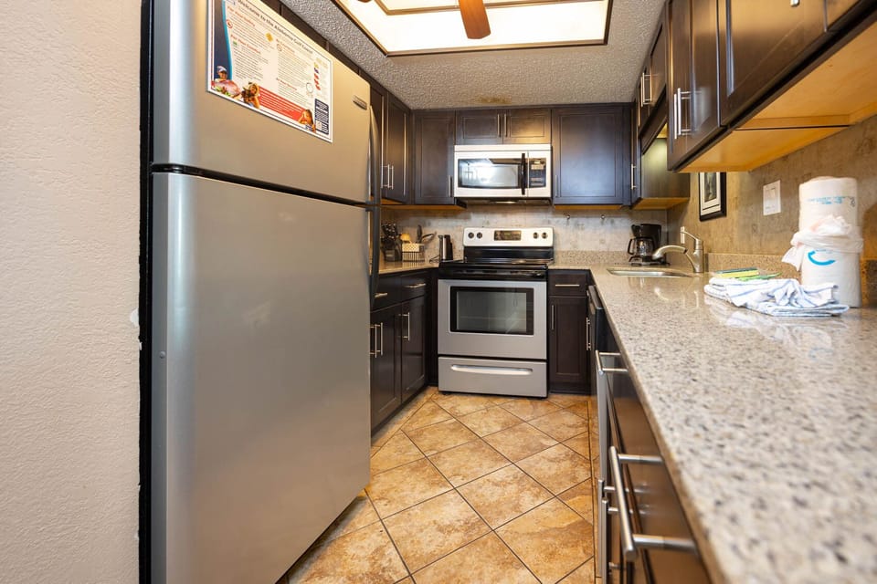 This kitchen features stainless appliances, granite countertops, and a coffee maker, perfect for your culinary adventures