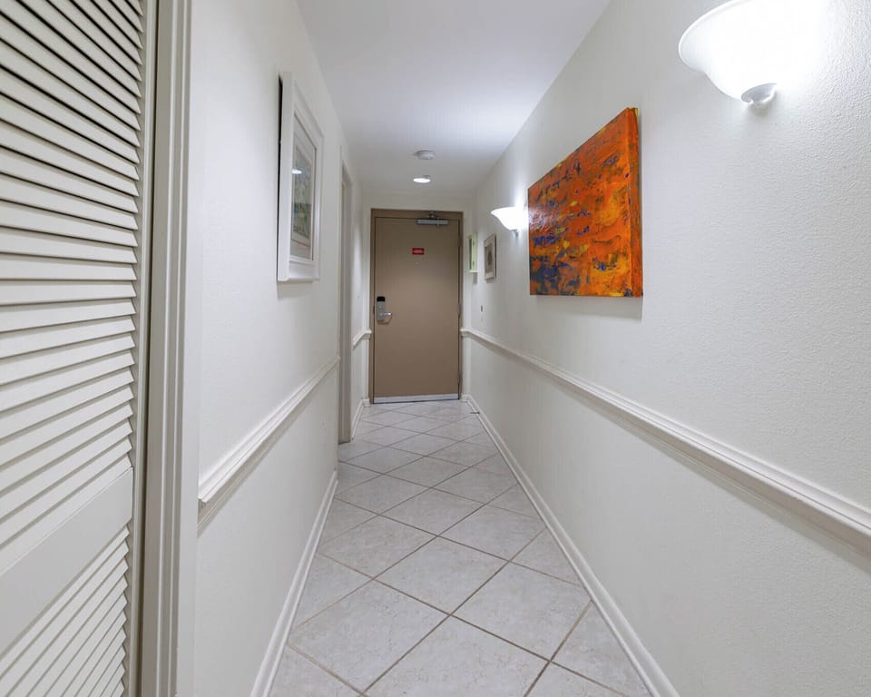 Step into a welcoming hallway adorned with artwork, leading you to your beachfront vacation retreat