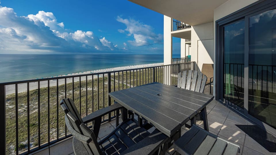 Balcony seating offers a serene view of the tranquil beach and sparkling gulf waters, perfect for relaxation