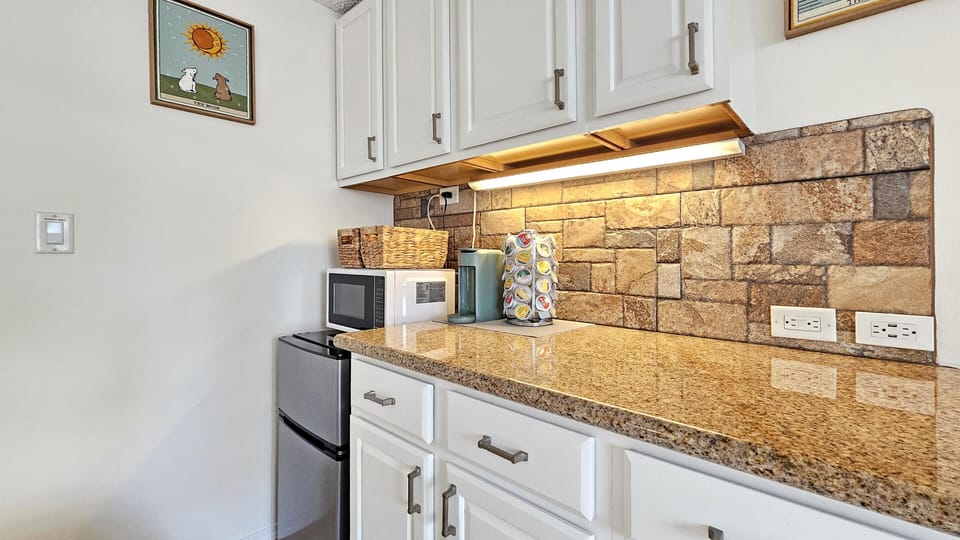 Cozy kitchen nook with warm stone backsplash and granite counters