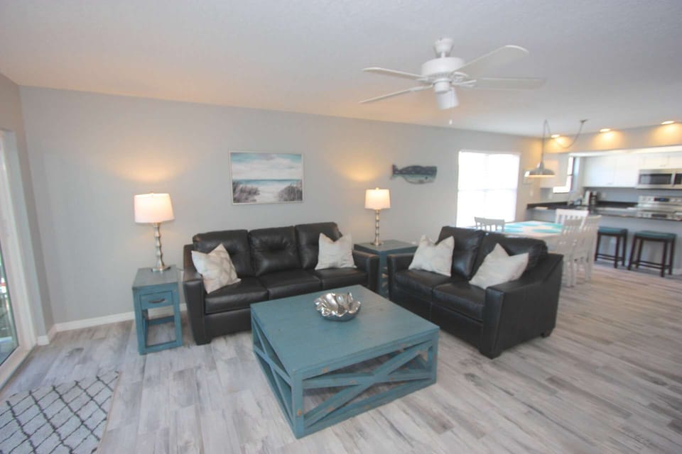 Relax after a Day at The Beach in the Spacious Living Room featuring Leather Sofas and a Large Flat Screen TV