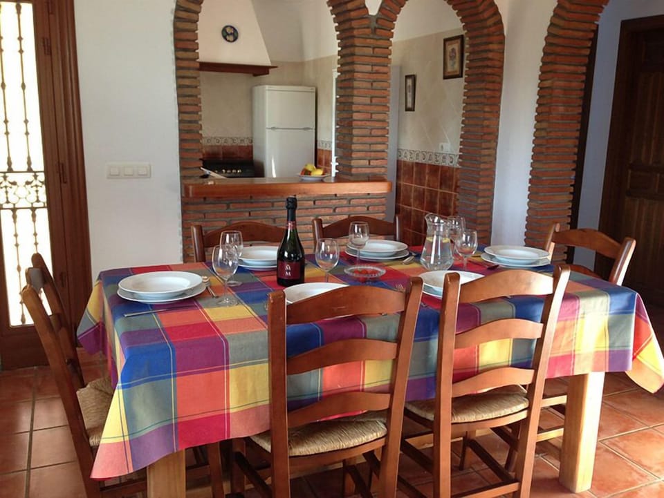Dining area with large wooden table and plenty of chairs.
