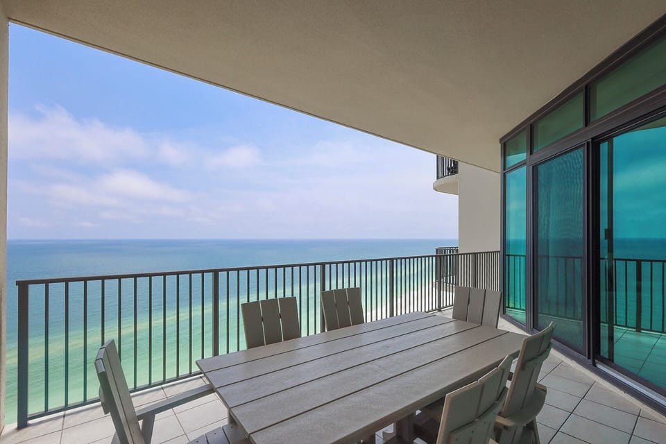Relax at your balcony table, soaking in the stunning coastal views while you unwind with loved ones