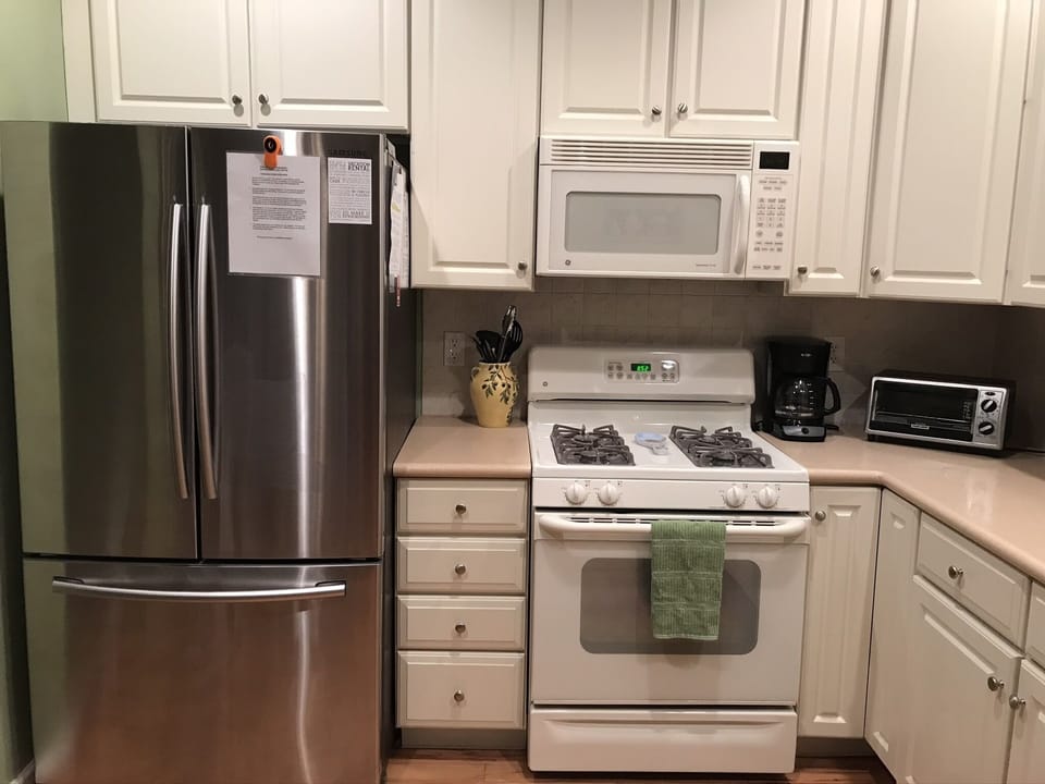 Full L-shaped kitchen with gas oven, microwave, dishwasher & stainless fridge