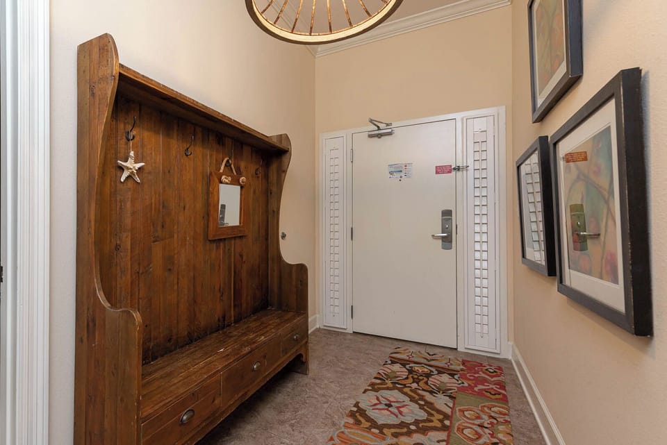 This welcoming entryway features a rustic wooden bench, a mirror, and colorful artwork, setting a charming tone for your stay