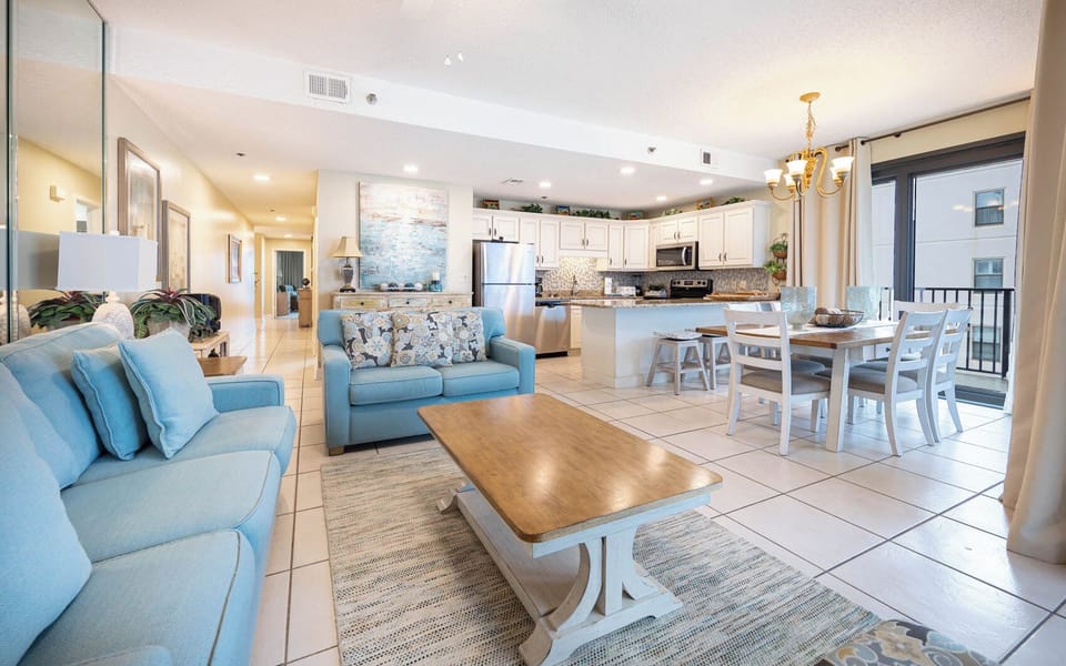 Unwind in the spacious living area with plush seating, a dining table, and a kitchen that invites culinary creativity