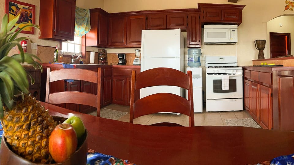 Kitchen area with handcrafted mahogany table seating 6 along with 3 at bar area