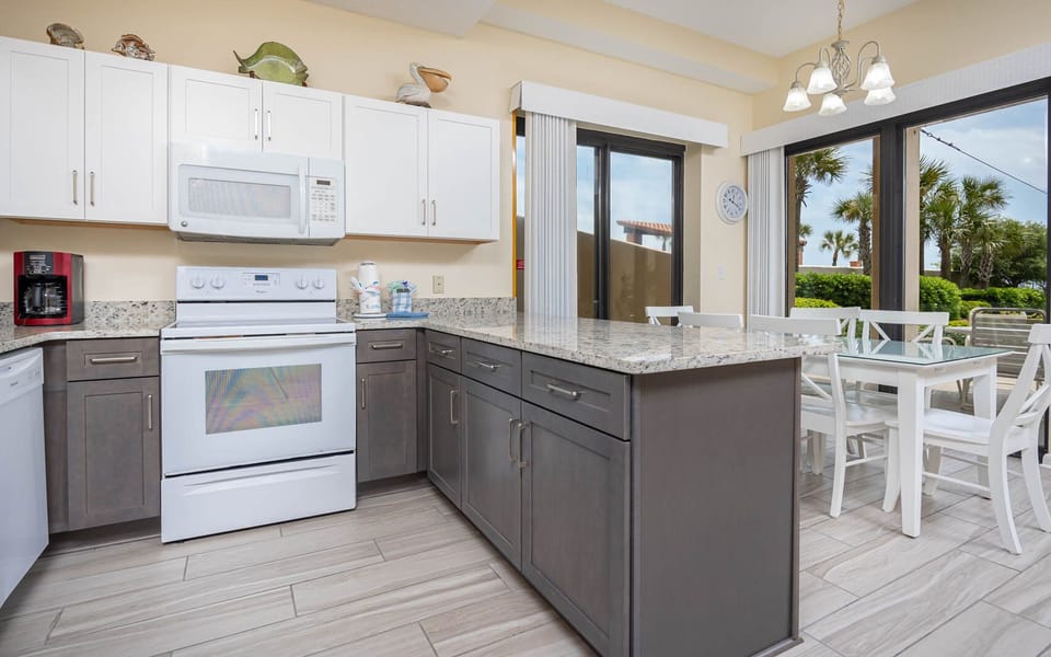 Cook and gather in this inviting kitchen featuring granite countertops, white appliances, and dining space with a view