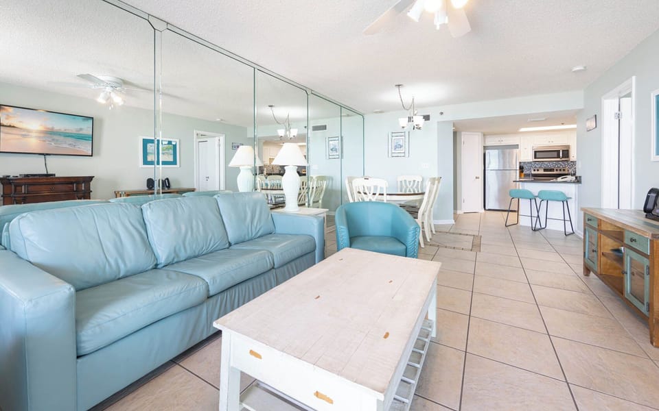 Relax on the soft leather sofa while enjoying the view of the dining area and kitchen in this inviting living space
