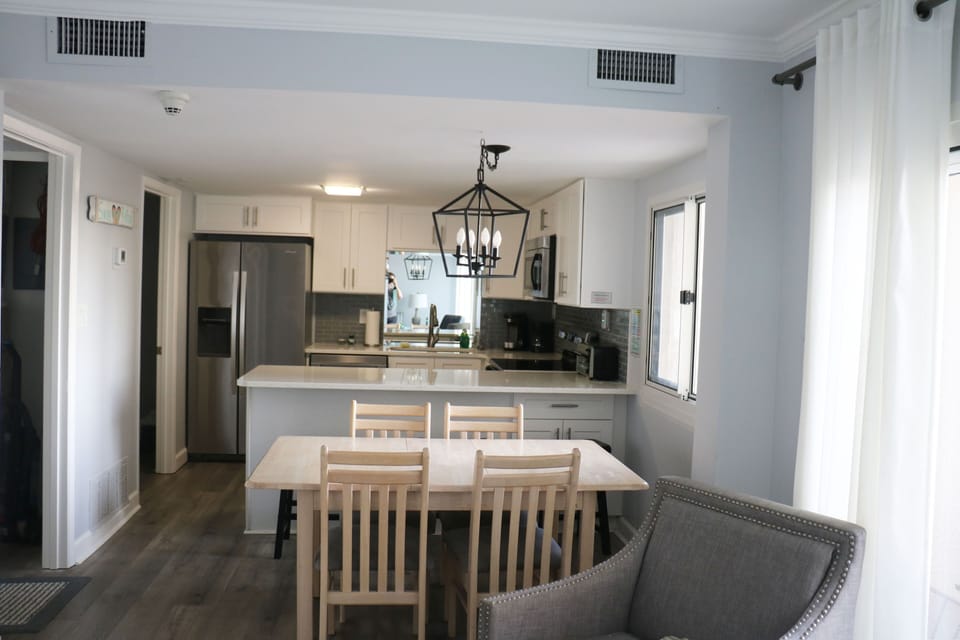 Dining area features table seating for 4 and 3 bar stools at the counter