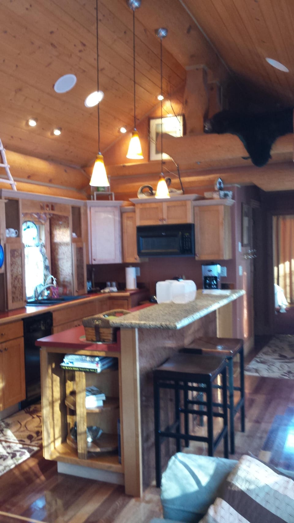 Fully stocked kitchen with granite counter eating area with stools.