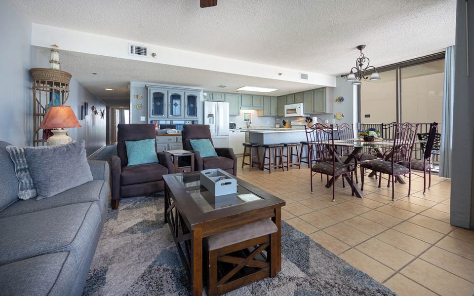 The inviting living area features plush seating, a stylish coffee table, and a dining space with elegant metal chairs