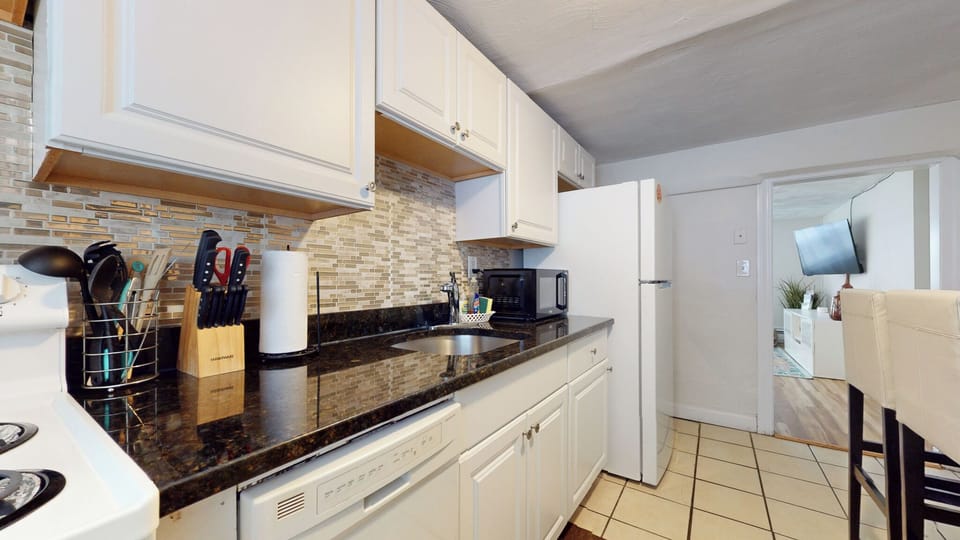Modern kitchen with sleek countertops and white cabinetry.