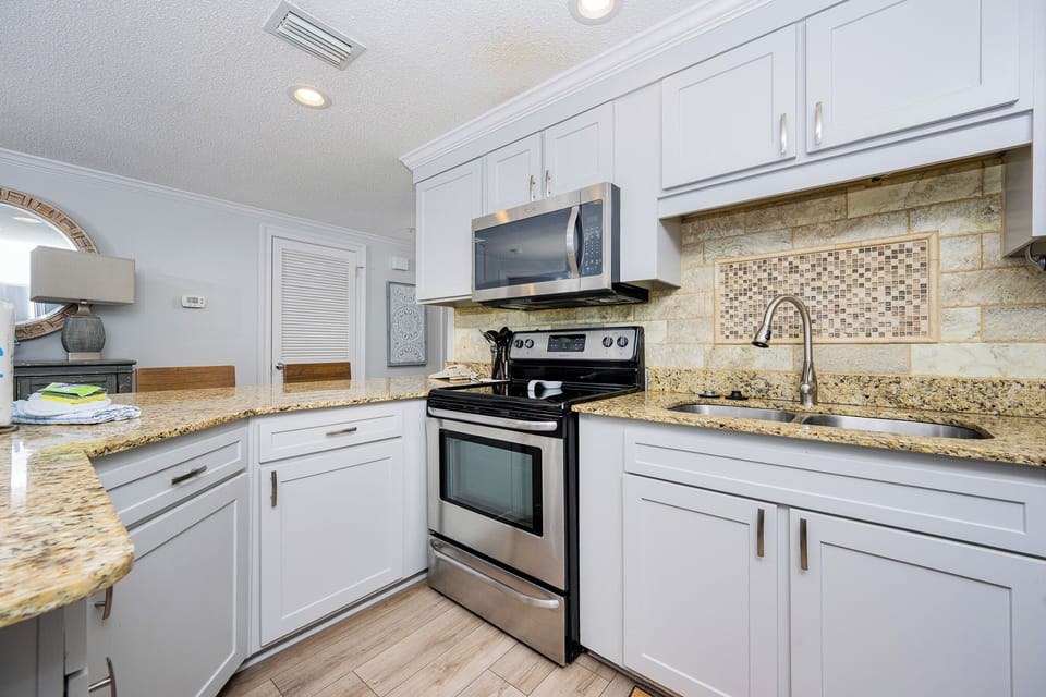 Prepare meals in the stylish kitchen featuring granite countertops, stainless appliances, and stylish design