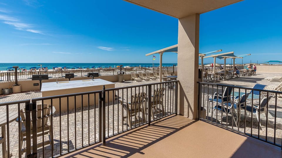 Step onto the spacious outdoor area with seating, perfect for enjoying the refreshing breeze and nearby beach views