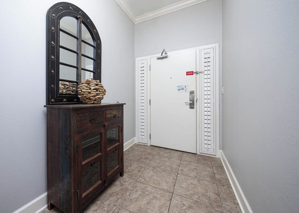 A charming entryway features a rustic wooden console table, a decorative mirror, and easy access to the front door