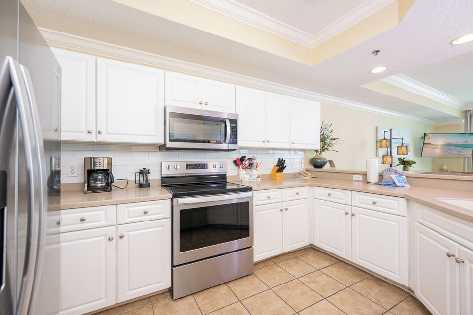 Prepare meals in this modern kitchen featuring stainless steel appliances, ample counter space, and light decor