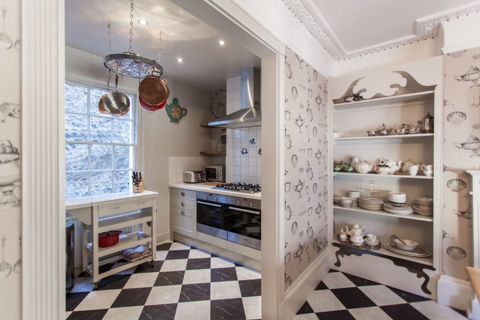 Fully equipped kitchen/diner with vintage cake stands, crockery and cutlery