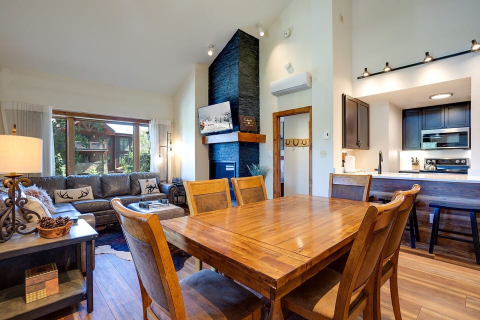 Cozy up by your beautiful stone fireplace while enjoying meals at your elegant dining table with mountain views streaming through windows.