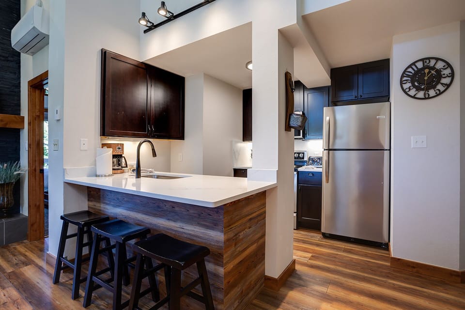 Your fully equipped kitchen features sleek countertops, modern appliances, and a breakfast bar where you can enjoy morning coffee.