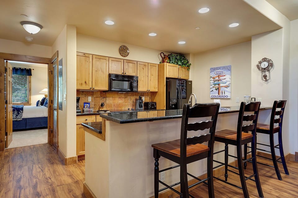 Your spacious kitchen features granite countertops, modern appliances, and a breakfast bar where you can enjoy morning coffee with mountain views.