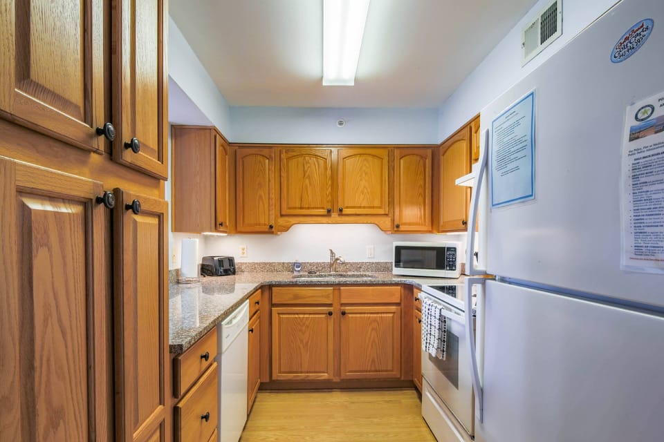 The kitchen is stocked with an electric range, dishwasher, microwave, refrigerator and toaster.