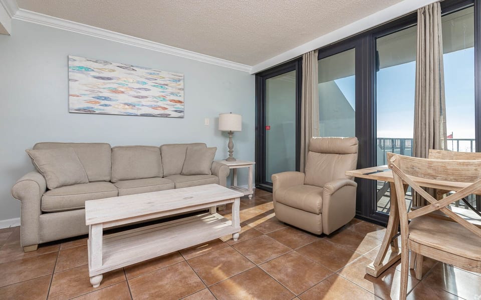 This inviting living room features a cozy sofa and a recliner, with stunning views just beyond the glass doors